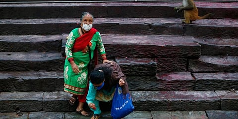 Women wearing masks offer prayers during Kuse Aunsi festival on the banks of Bagmati river near Pashupatinath temple in Kathmandu. (Photo | AP)