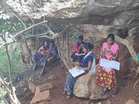 Students from the tribal villages of Pachamalai hill in Tiruchy sitting on hill top to get internet. (Photo| EPS)