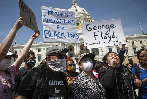 Ze Thao, second from right, addresses a Black Lives Matter rally for George Floyd with fellow Hmong activist Youa Vang Lee, center, at the Minnesota State Capitol. (Photo | AP)