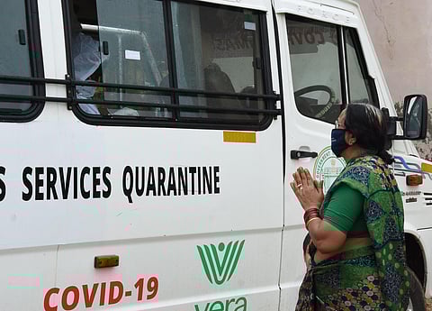 A women praying before getting covid 19 test at iMSAQ van. (Photo | EPS/RVK Rao)