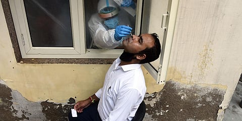 A health worker collects swab samples for COVID-19 Rapid Antigen detection testing in New Delhi. (Photo| Parveen Negi, EPS)