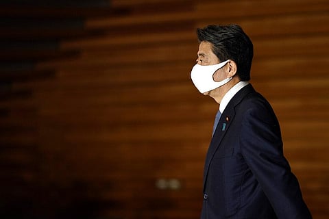 Japan's Prime Minister Shinzo Abe wearing a face mask walks after his press conference in Tokyo (Photo | AP)