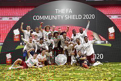 Arsenal players pose with the trophy after winning the English FA Community Shield football match between Arsenal and Liverpool. (Photo | AP)