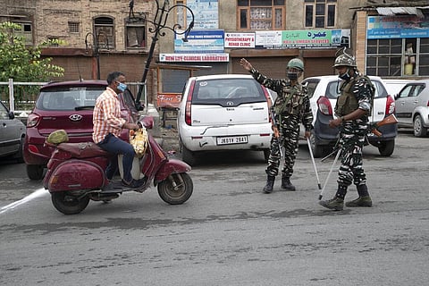 Indian paramilitary soldiers stop a Kashmiri man traveling to visit relatives for Eid during lockdown to curb the spread of coronavirus in in Srinagar, Saturday, Aug. 1, 2020. (Photo | AP)