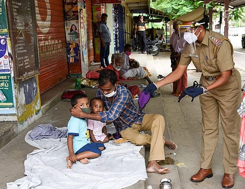 Jothimani, inspector of serious crime squad distributing food packets and mask to destitutes under her own money in Tiruchy on Sunday. (Photo| MK Ashok Kumar, EPS)