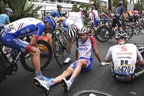 French rider Thibault Pinot, center, sits after falling during the first stage of the Tour de France cycling race over 156 kilometers with start and finish in Nice. (Photo | AP)