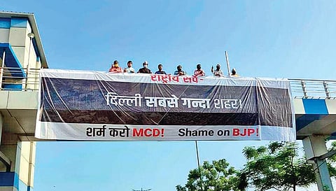 AAP workers with a banner they put up at a foot overbridge on Saturday | twitter