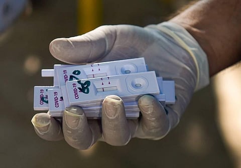 A health worker holds samples collected from construction workers for COVID-19 test via rapid antigen testing. (File Photo | PTI)
