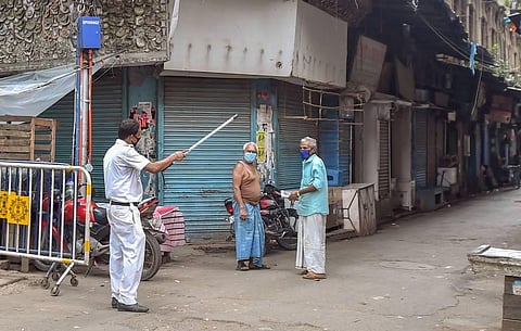 A policeman instructs local residents to go back their houses during a complete lockdown to curb the spread of coronavirus in Kolkata. (Photo | PTI)