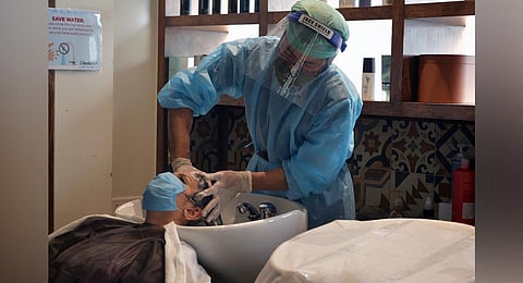 A woman gets her hair washed at a salon in Bengaluru, as the city opens up for more economic activity. (Photo | Meghana Sastry, EPS)