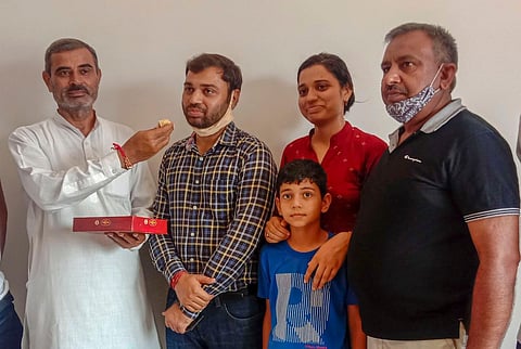 Pradeep Singh who got the first rank in the Civil Services Exams 2019 being offered sweets by his father-in-law at their residence in Sonipat on Tuesday. (Photo | PTI)