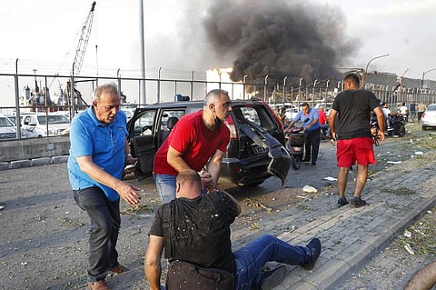 Port workers help their injured friend at the scene of an explosion that hit the seaport of Beirut, Lebanon, Tuesday, Aug. 4, 2020. (Photo | AP)