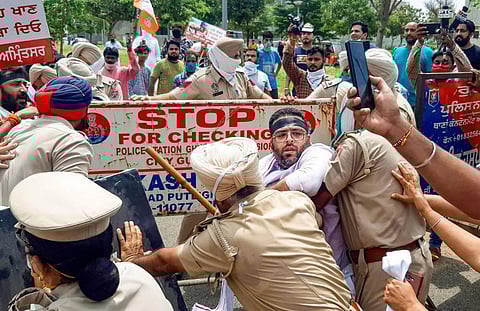 Punjab Police try to stop workers of the Bharatiya Janata Yuva Morcha who were marching towards the residence of MLA Navjot Singh Sidhu during a protest over the hooch tragedy. (Photo | PTI)
