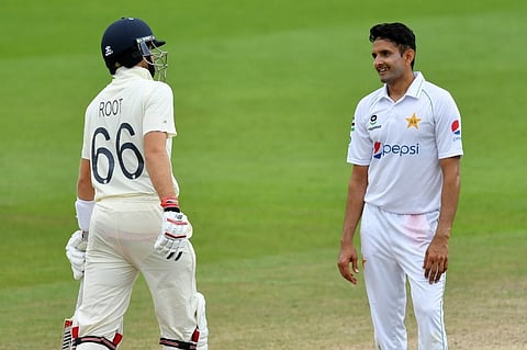 Pakistan's Mohammad Abbas (R) shares a moment with England's Joe Root (L) during play on the fourth day of the first Test cricket match. (Photo | AFP)