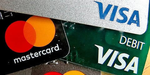 Credit cards are displayed in Zelienople, Pa. U.S. consumer borrowing rose in June after three months of declines but the key category of credit card debt extended its decline. (Photo | AP)
