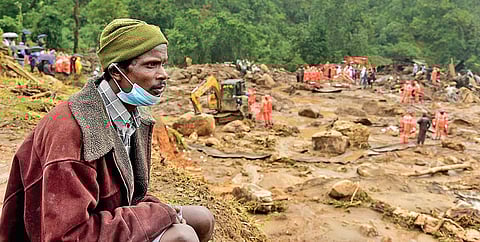 Shanmukhayya, who ran to the workers’ quarters to alert the residents about landslide on hearing the roaring sound, looks on as earthmovers remove huge boulders searching for missing people at Pettimu