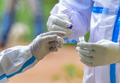 A medic wearing PPE kit stores samples for COVID-19 testing at a government hospital. (Photo | PTI)