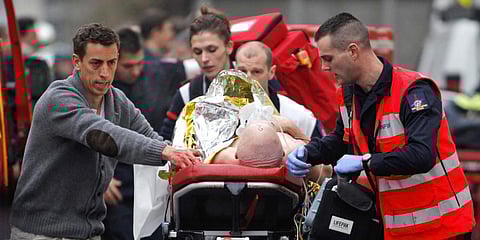 In this Jan. 7, 2015 photo, an injured person is transported to an ambulance after a shooting at the French satirical newspaper Charlie Hebdo's office, in Paris. (Photo | AP)