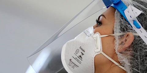 A health worker wears a face shield and mask as she tests for COVID-19. (Photo | AP)