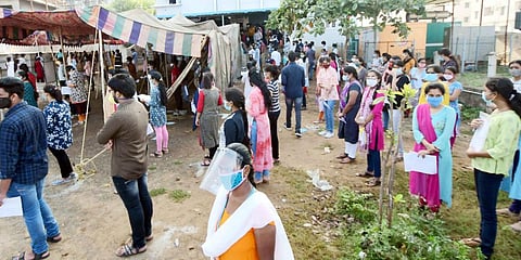 Students waiting outside the JEE Mains exam centre maintaining social distancing at Chinna Mushirawada in Visakhapatnam on Friday. (Photo| G Satyanarayana, EPS)