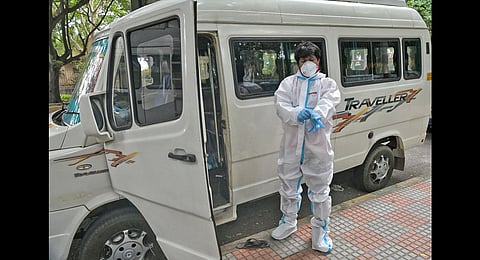 An ambulance driver wears a PPE kit before beginning his work | express
