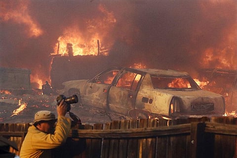 A news photographer takes pictures of a wildfire in the Lake View Terrace area of Los Angeles. (Photo | AP)