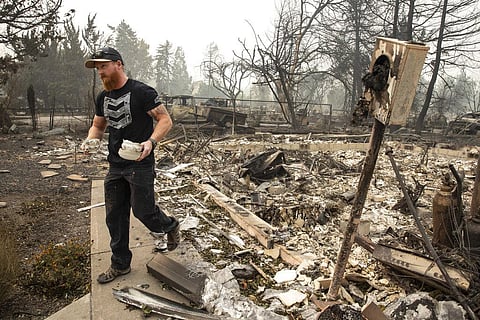Derek Trenton from Talent, Ore. salvages some items at his parents home as wildfires devastate the region, Friday, Sept. 11, 2020 in Talent, Ore. (Photo | AP)