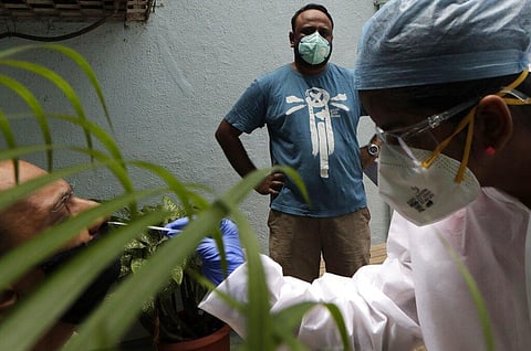 Health workers take swab sample to test for COVID-19 outside a residential building in Mumbai, India, Sunday, Sept. 13, 2020. (Photo | AP)