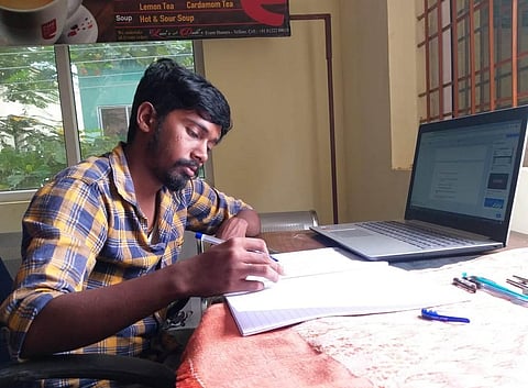 A postgraduate student taking the online exam at his workplace in Vellore city (Photo | EPS)