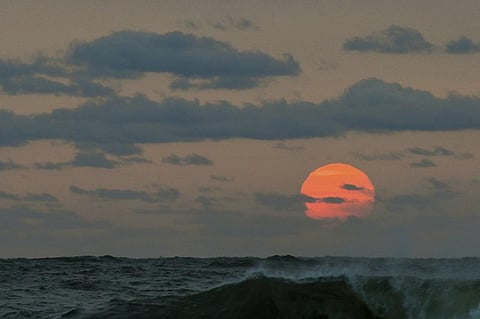 This photo taken at sunrise from Surf City on Long Beach Island in New Jersey shows the sun shrouded in smoke and brown haze Tuesday, Sept. 15, 2020. (Photo | AP)