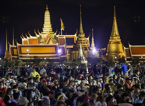 Pro-democracy demonstrators attend a protest at Sanam Luang with The Grand Palace lit up in the background in Bangkok, Thailand. (Photo | AP)