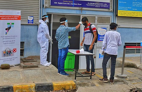 Students undergo thermal screening before entering an exam centre to write JEE Mains, in Bengaluru. ( Photo | Shriram B N, EPS)