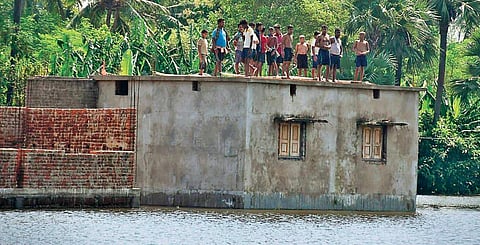 Flood-hit villagers take shelter on the roof of a building in Kendrapara district. (Photo| EPS)