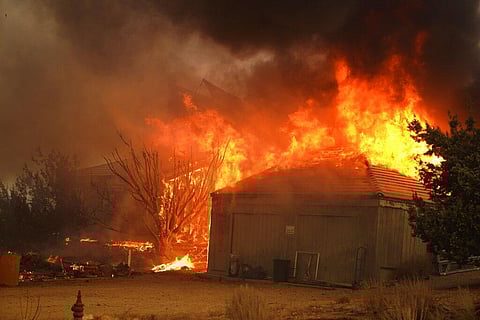 A home burns along Cima Mesa Rd. as the Bobcat Fire advances Friday (Photo | AP)