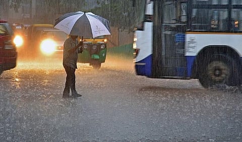 A man braves heavy rain at Queen’s Road junction on Saturday | vinod kumar t