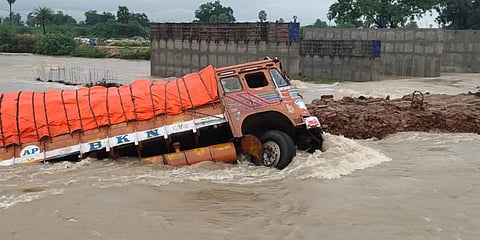 A lorry overturns due to the heavy flow of rainwater at Gadwal district's Nandinne Bridge. (Photo| EPS)