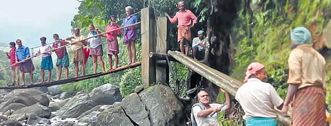 Local people make a wooden bridge at Maripuzha, Anakkampoyil, in Kozhikode for the team of officials carrying out the survey on Wednesday | Express