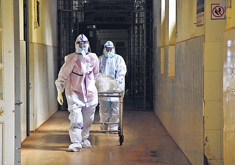 Medical workers wheel out the body of a Covid-19 victim on Saturday.