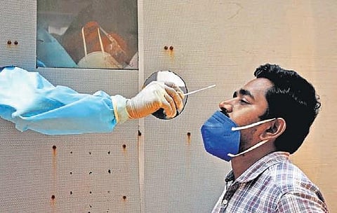 A man gives swab sample for Covid test in Vijayawada on Thursday | express