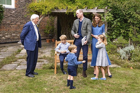 Britain's Prince William and Kate, the Duchess of Cambridge, react with Naturalist David Attenborough, left, with their children in the gardens of Kensington Palace in London. (Photo | AP)