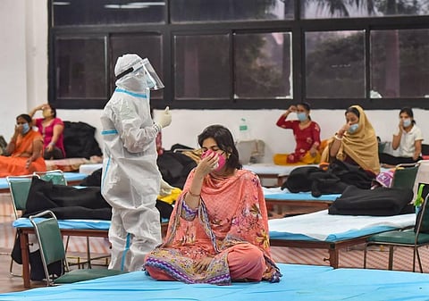 Patients perform yoga at CWG village COVID-19 Care Centre near Akshardham in New Delhi Sunday Sept. 27 2020. (Photo | PTI)