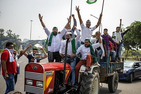 Farmers shout slogans as they ride tractors towards New Delhi to protests against newly passed Farm Laws. (Photo | AP)