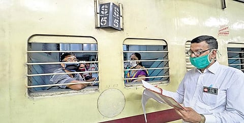 A TTE checks reservation status of passengers from outside the window of a special train in Bhubaneswar on Wednesday | irfana