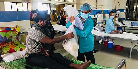 A volunteer of Mission Save Bangladesh distributes food packages at a Cancer hospital in Dhaka. (Photo| AP)