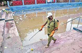 A Belagavi corporation worker sanitises the area around Kapileshwar lake, where Ganesha idols were immersed on Wednesday. (Photo | Ashishkrishna HP/EPS)