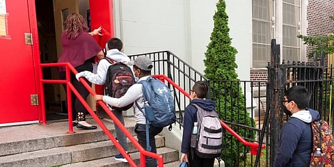 A teacher leads her students into an elementary school in the Brooklyn borough of New York. (Photo | AP)