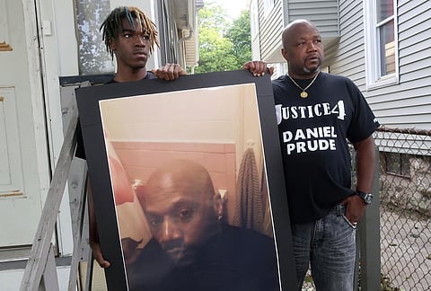 Joe Prude, uncle of Daniel Prude, right, and Daniel's nephew Armin, stand with a picture of Daniel Prude in Rochester, N.Y., on Thursday, Sept. 3, 2020. (Photo | AP)