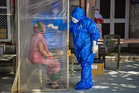 A medic collects samples from a woman for COVID-19 test as coronavirus cases surge across the country. (Photo | PTI)