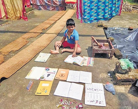A boy drying his books in flood-hit Binjharpur block of Jajpur district  I Akshya Rout