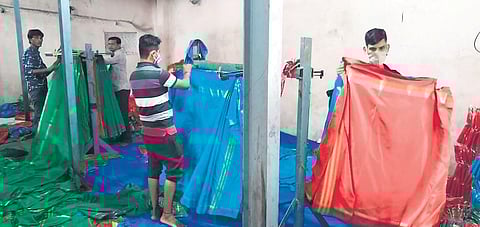 Workers ready the Bathukamma  sarees that are to be distributed this year, at a handloom unit in Rajanna-Sircilla district on Thursday. With manufacturing processes over, the workers are now busy fold
